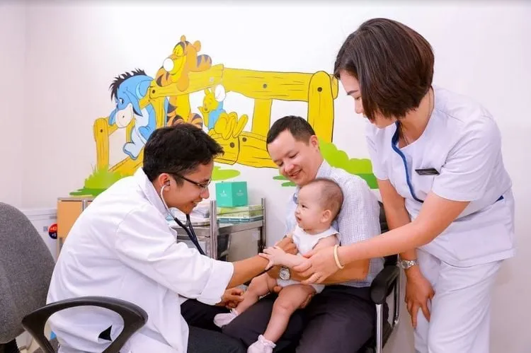 Bác sĩ nhi khoa đang khám cho em bé, thể hiện tầm quan trọng của việc tham khảo ý kiến chuyên gia y tế khi trẻ bị sổ mũi nghẹt mũi.